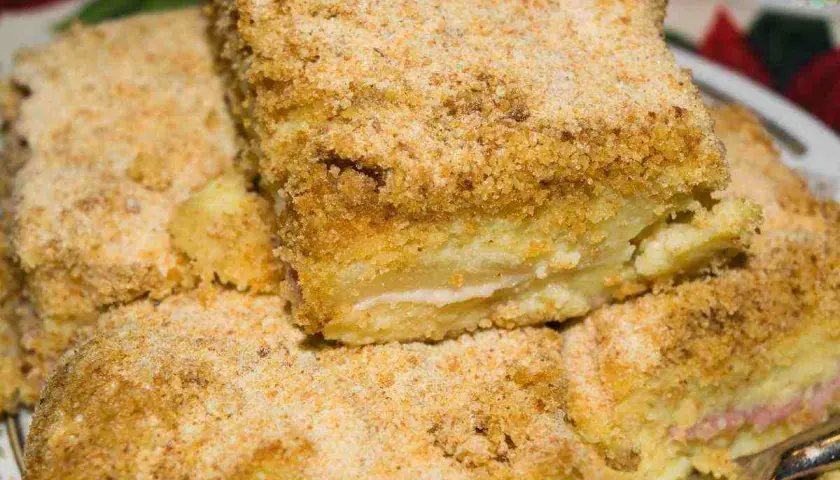 Fette di gattò di patate dorato e croccante, un classico della cucina casalinga, pronto per essere gustato.