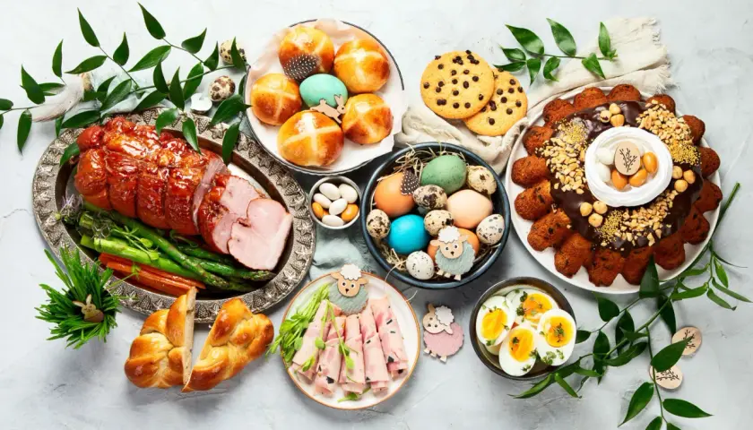 Wielkanocny stół pełen smakołyków: pieczona szynka, pascha, jajka, babki, ciasteczka i inne pyszności. Idealne co do jedzenia na wielkanoc.