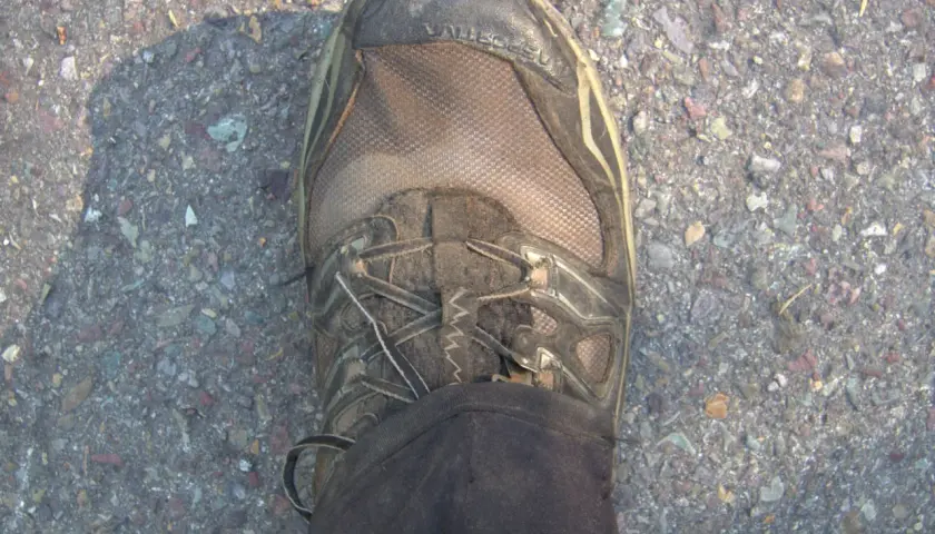 Dirty Gore-Tex hiking boot on gravel. Learn how to clean Gore-Tex shoes to keep them waterproof and ready for your next adventure.