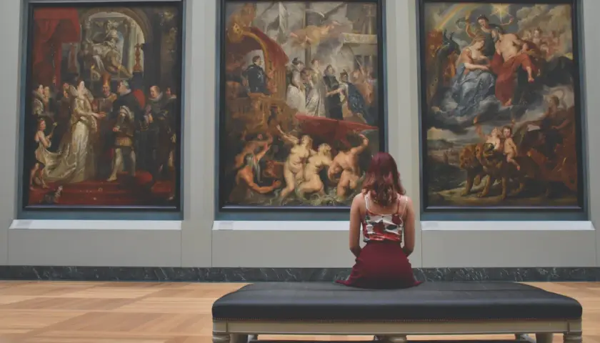 Una donna ammira tre grandi dipinti in un museo, forse provando la sindrome di Stendhal cos'è.