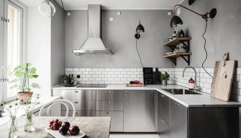 Cuisine moderne avec armoires en inox, parfait pour comment reconnaître de l'inox. Le plan de travail en marbre et le carrelage métro blanc complètent le look.