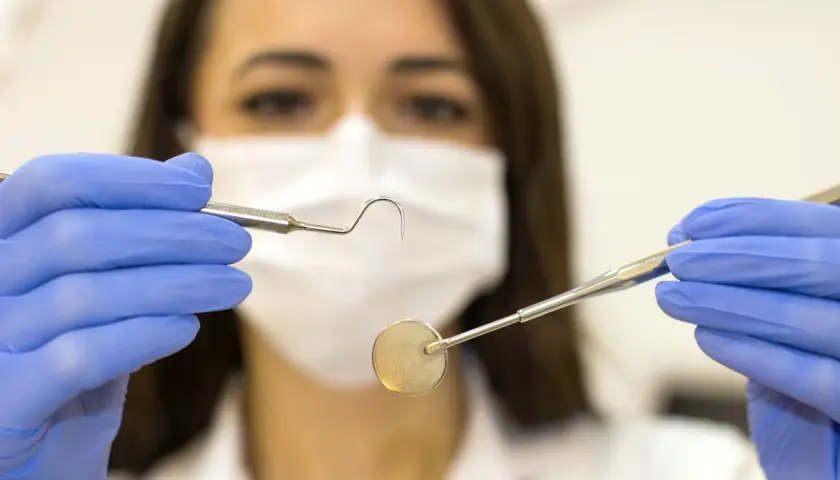 Igienista dentale con strumenti, un'idea di quanto guadagna un igienista dentale privato.