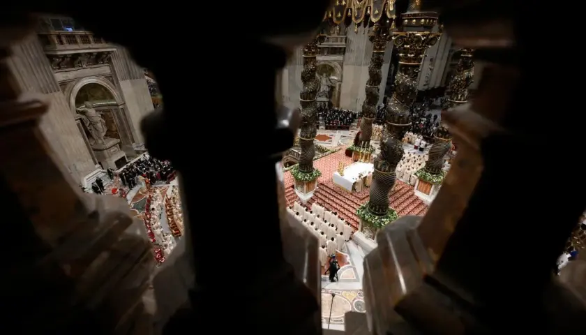 Blick von oben in eine prunkvolle Kirche. Gläubige und Geistliche versammeln sich, um an einer Zeremonie teilzunehmen. Extra omnes.