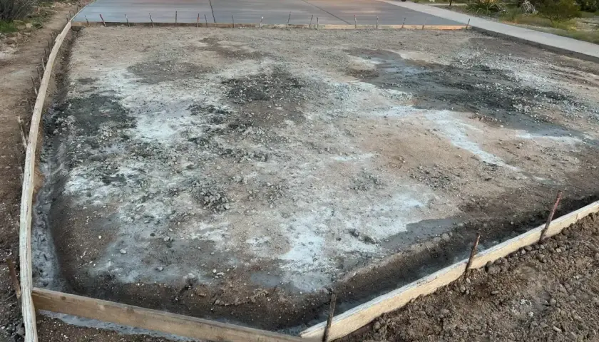 Plac budowy podjazdu z kamienia. Widać szalunki i przygotowany teren pod wylanie betonu.