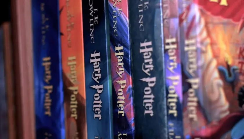 Grzbietami książek z serii Harry Potter, które pozwalają zgłębić, ile Harry Potter ma lat w każdej z części.
