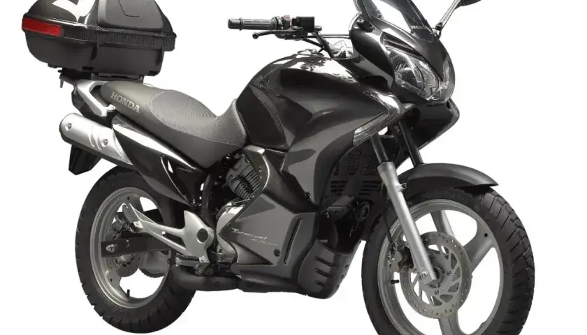 Czarny motocykl Honda Varadero 125 z kufrem. Odblokowanie mocy silnika to klucz do pełnego potencjału tej maszyny.