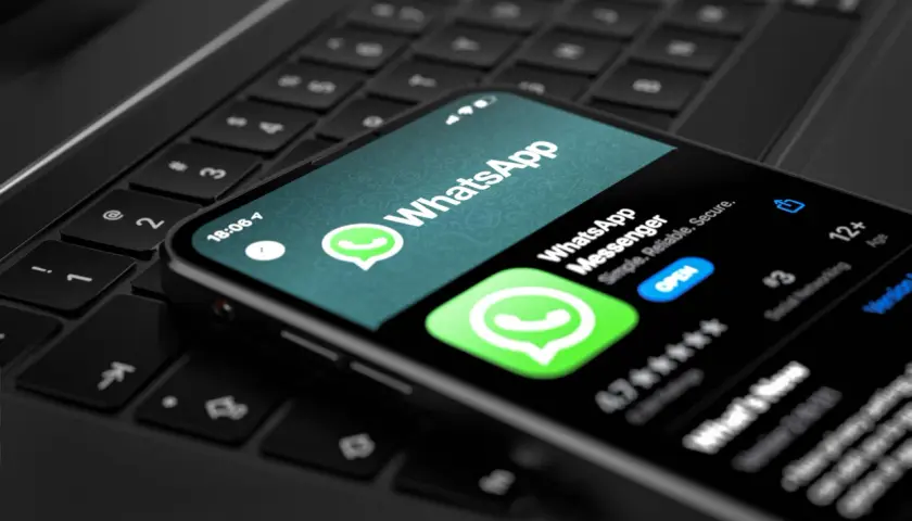 Telefon z aplikacją WhatsApp na klawiaturze laptopa. Wygodny sposób na korzystanie z WhatsApp na komputerze.