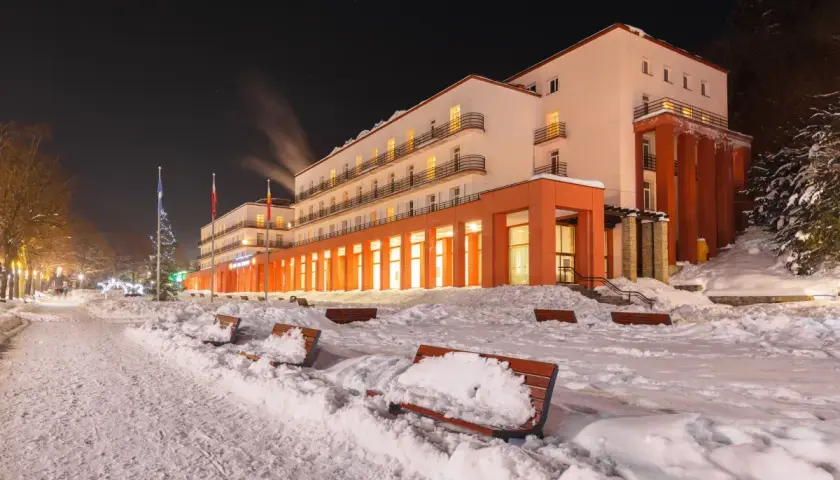 Zimowy wieczór przed sanatorium. Warto sprawdzić nowe zasady wyjazdu do sanatorium na NFZ, by cieszyć się wypoczynkiem.