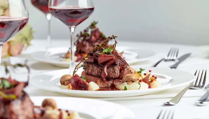 Eleganckie danie z wołowiny z puree, grzybami i cebulą, podane z czerwonym winem. Idealne na specjalne okazje, zastanawiasz się, ile za osobę na wesele?