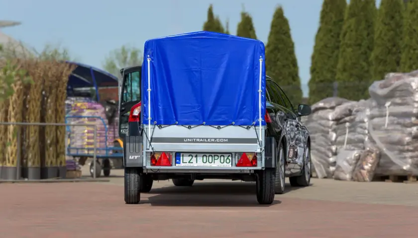 Ciężarówka z naczepą, przykryta niebieską plandeką, gotowa do transportu. Zastanawiasz się, ile waży ciężarówka z naczepą?