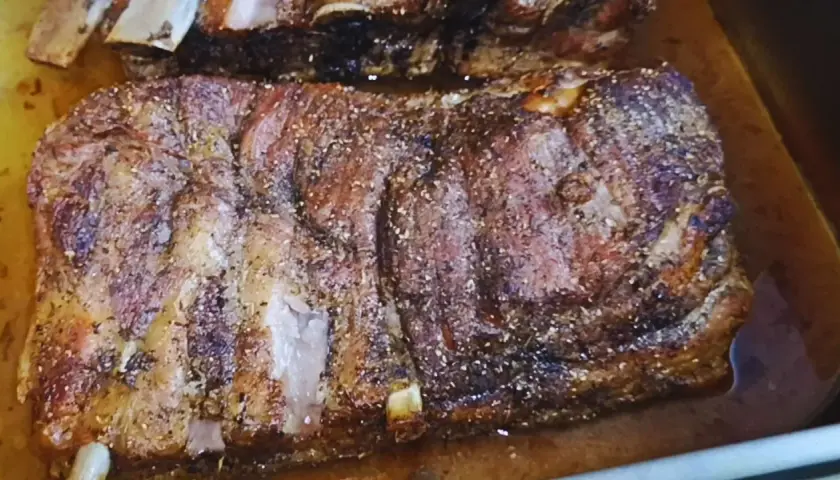 Pyszne żeberka pieczone w piekarniku w naczyniu, przyprawione i rumiane.