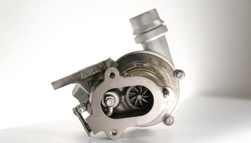 Metalowa turbosprężarka z widocznymi łopatkami wirnika. To serce każdego silnika, które dzięki technologii turbo compound zwiększa moc.