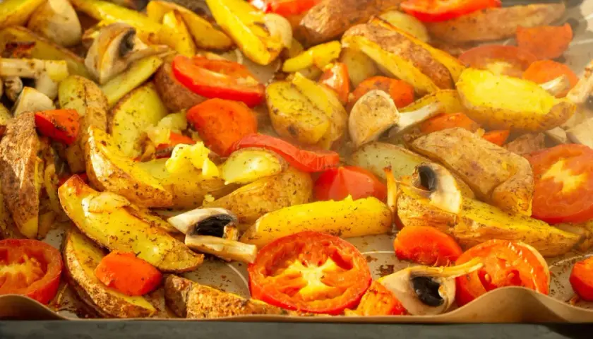 Pieczone ziemniaki, pomidory i pieczarki, przygotowane z użyciem funkcji grill w piekarniku.