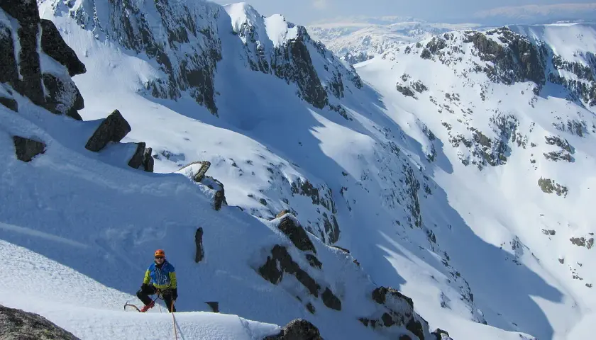 Alpinista en pendiente nevada, listo para ascender. Una escena perfecta para cursos de alpinismo.