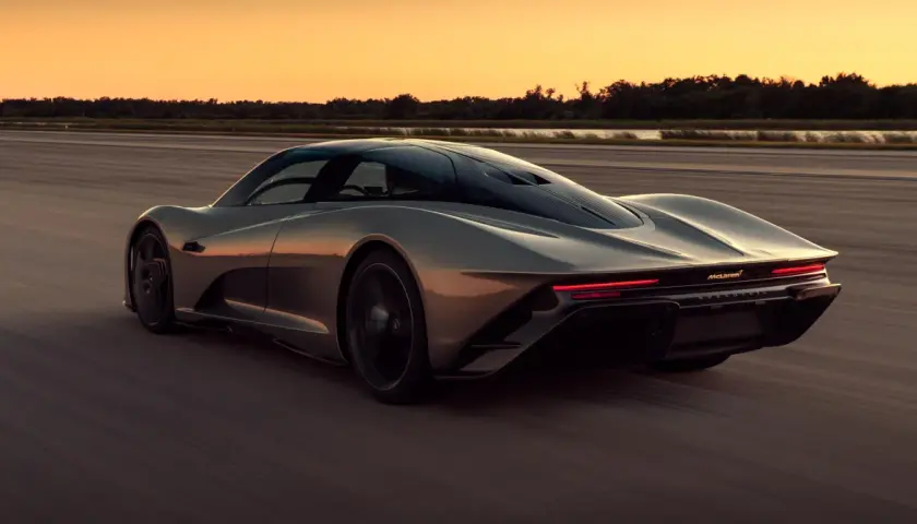 Szary McLaren Speedtail pędzi po pustej drodze o zachodzie słońca.