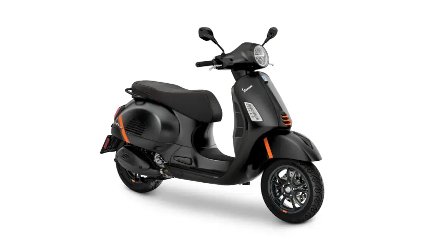 Vespa GTS 300 negra con detalles naranjas, asiento deportivo y llantas de aleación.