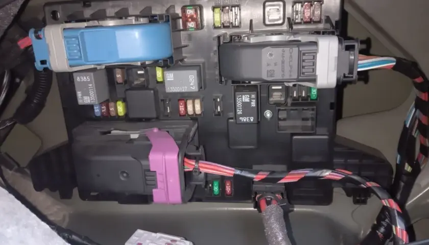 Panel bezpieczników w Opel Astra J, z widocznymi bezpiecznikami i przekaźnikami.