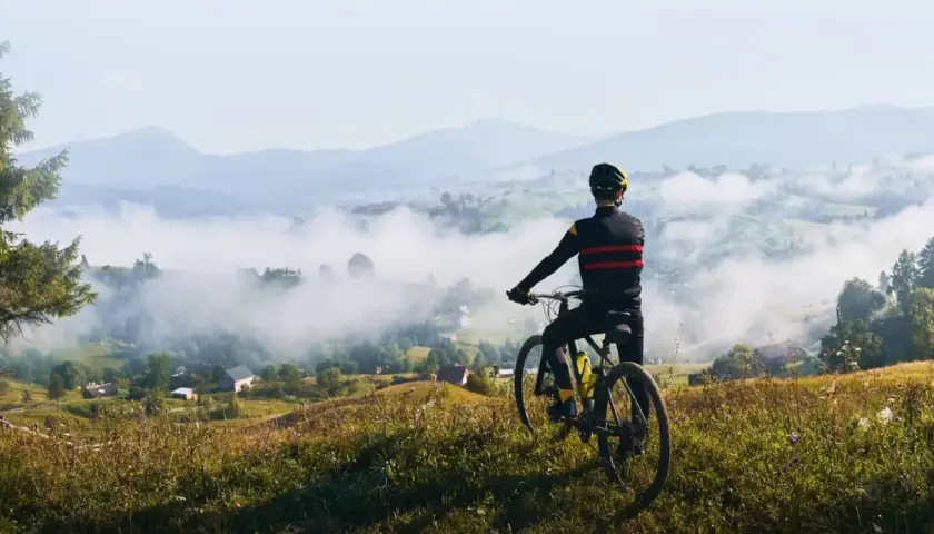 Rowerzysta podziwia mglisty krajobraz Dolnego Śląska. Widok na dolinę i góry.