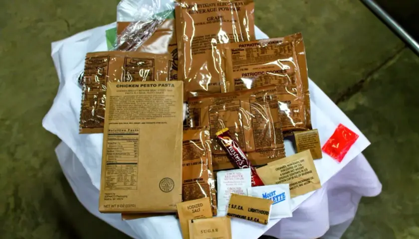 MRE polskie: paczka z daniem "Chicken Pesto Pasta", ciastka, napój, cukier, sól, pieprz i inne dodatki.