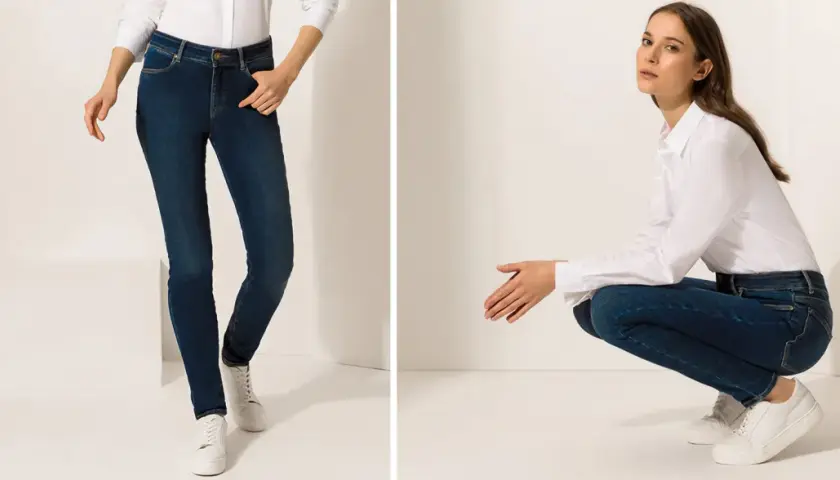Zwei Frauen in Jeans und weißen Hemden, eine stehend, die andere hockend.