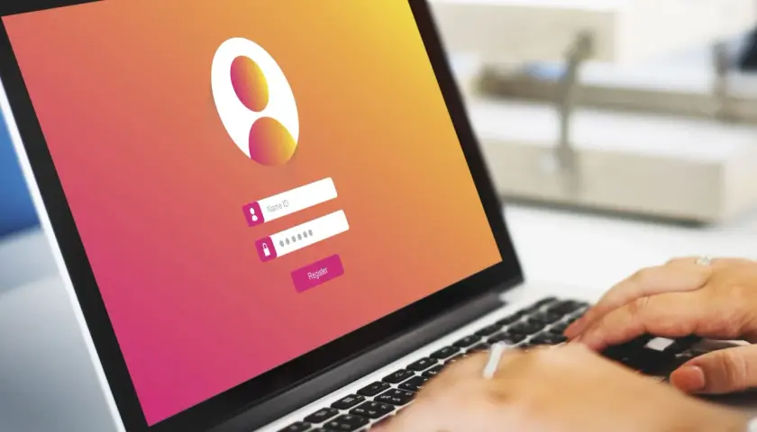 Laptop con pantalla de inicio de sesión. Se ve un campo para "Name ID" y otro para contraseña, con un botón "Register". La interfaz parece ser una firma digital en Google Chrome.