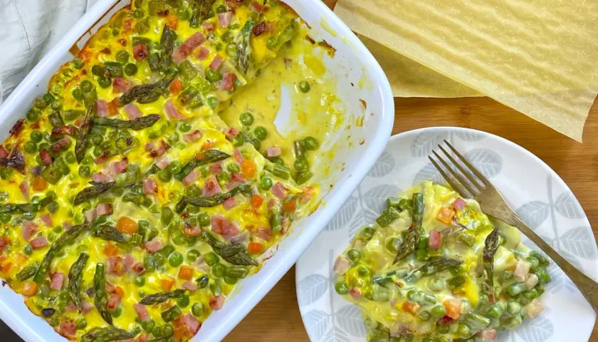 Lasagne primavera con asparagi, piselli e prosciutto cotto, un piatto colorato e gustoso.