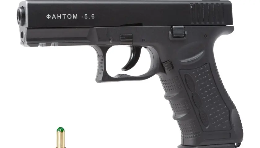 Czarny pistolet hukowy 6mm z Czech, model "ФАНТОМ -5.6", obok naboju.