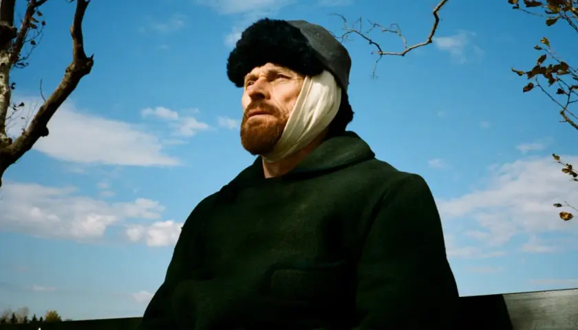 W filmie o van Goghu Willem Dafoe jako malarz z zabandażowanym uchem, w czapce i ciemnym płaszczu, patrzy w niebo.