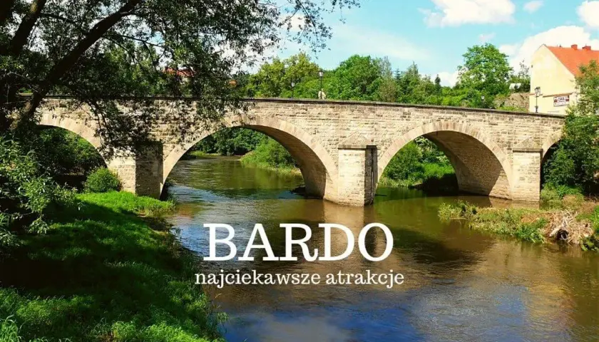Kamienny most w Bardo Śląskim nad rwącą rzeką, otoczony zielenią. Idealne miejsce na podróże bez ości.