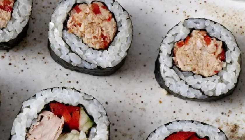 Roladki sushi z ryżem i nori, wypełnione rozdrobnionym tuńczykiem w sosie własnym, papryką i ogórkiem.