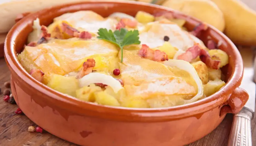 Plat gratiné avec pommes de terre, lardons et fromage à raclette fondant. Une recette réconfortante pour les soirées d'hiver.