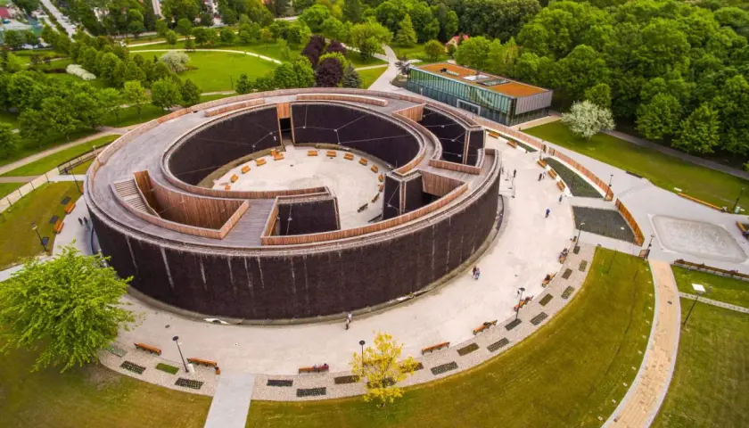 Nowoczesne termy w Busku-Zdroju, spiralna tężnia z drewnianymi elementami i otaczający ją park.