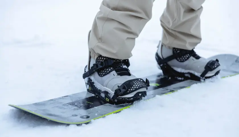 Zbliżenie na buty snowboardowe w wiązaniach. Dowiedz się, jak ustawić wiązania snowboard, by cieszyć się jazdą.