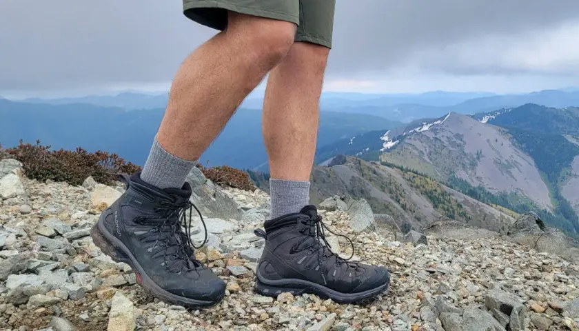 Hiking boots on a rocky summit. These boots look like they could last for years, answering the question: how long do leather boots last?