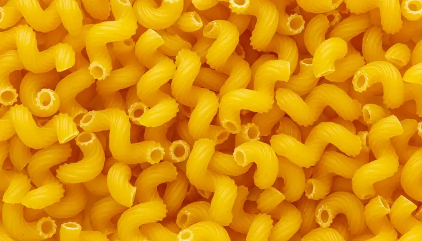 Góra żółtego makaronu cavatappi. Zastanawiasz się, ile białka ma makaron?