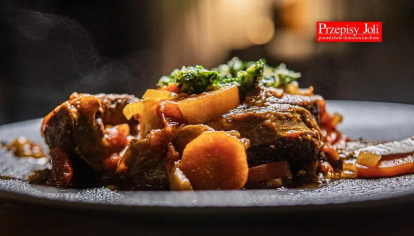 Pyszne, parujące ossobuco wołowe z warzywami na talerzu. Aromatyczne danie, które rozpływa się w ustach.