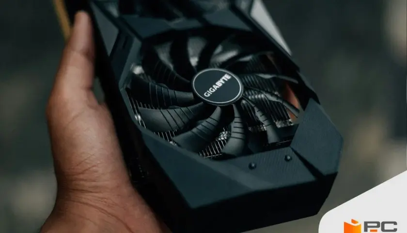 Mano sostiene una tarjeta gráfica Gigabyte, esencial para el rendimiento de tu PC.