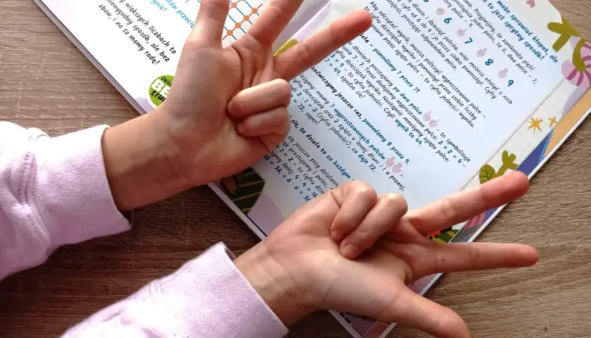 Sprytny sposób na tabliczkę mnożenia: palce pokazują liczby od 6 do 9. Dziecko uczy się mnożyć, używając dłoni.