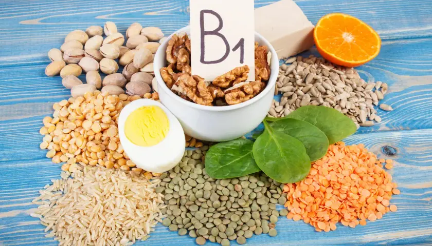 Vielfalt an vitamin b1 lebensmittel: Nüsse, Linsen, Reis, Erbsen, Ei, Spinat, Sonnenblumenkerne, Orange und Hefe.