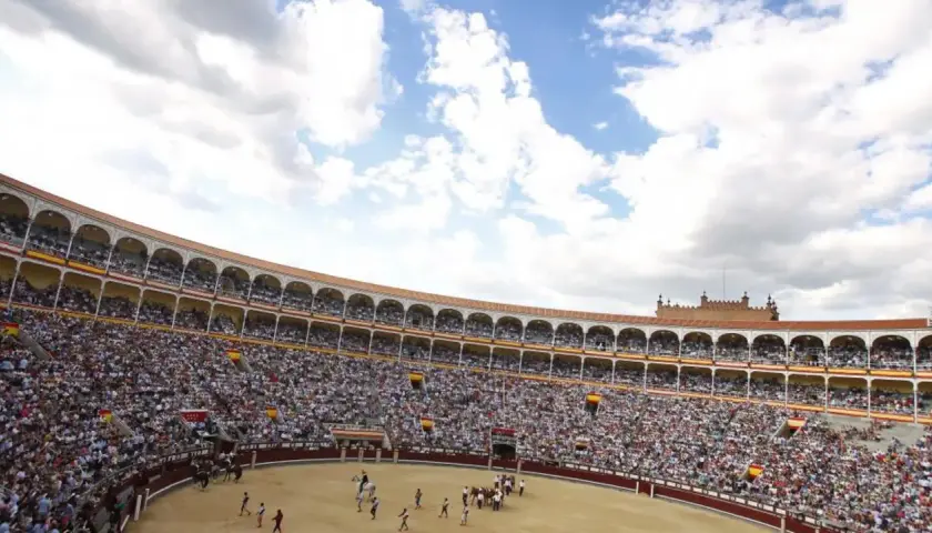 Gran multitud asiste a una corrida de toros. El sol brilla en el cielo azul con nubes blancas. ¡Una visita a la plaza de toros es una experiencia inolvidable!