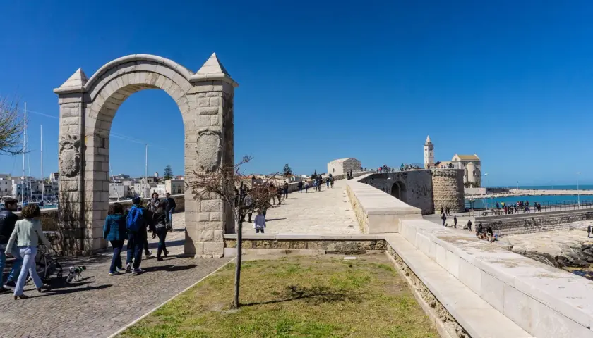 Arco monumentale e passeggiata sul lungomare, con la cattedrale in lontananza. Ecco cosa vedere a Trani.