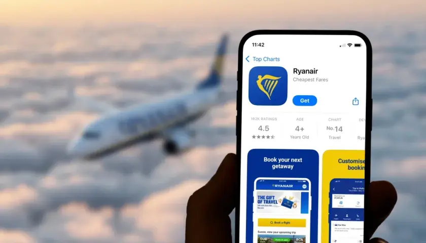 Telefon z aplikacją Ryanair na tle samolotu. Dowiedz się, jak wydrukować kartę pokładową z aplikacji Ryanair, by podróżować bez stresu.