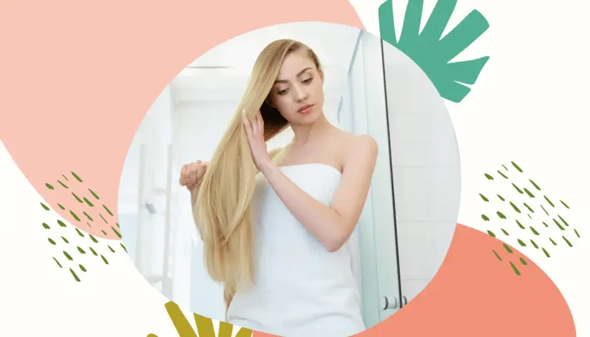 Blondynka owinięta ręcznikiem dotyka swoich długich włosów, które lśnią dzięki zabiegowi zakwaszania.