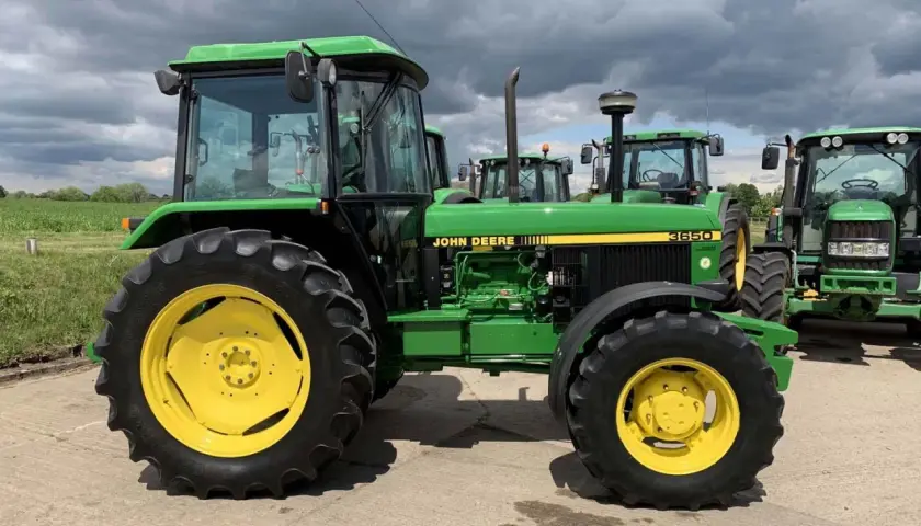 Zielony John Deere 3650 z żółtymi felgami, gotowy do pracy na polu.
