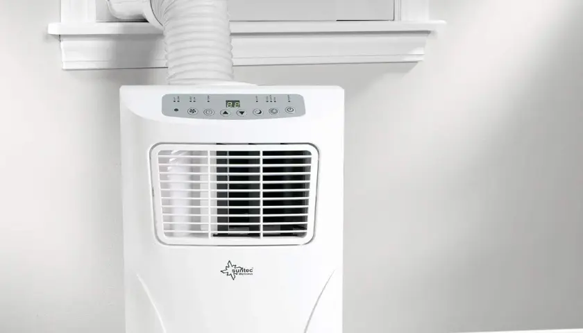 Un aire acondicionado portátil con un tubo para sacar aire caliente por la ventana.