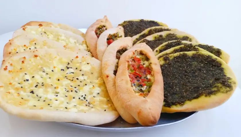 En bricka med manakish zaatar, ost och grönsaksfyllning.