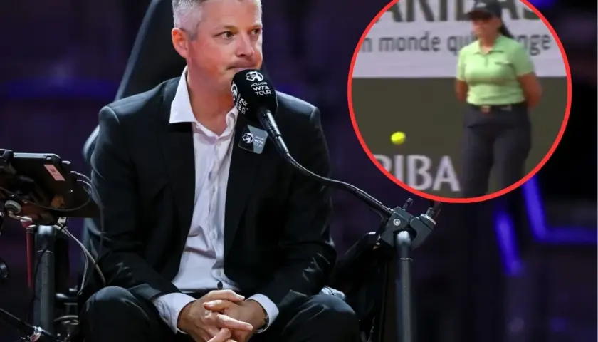 Sędzia na bieżni, w tle kobieta w zielonej koszulce i piłka tenisowa.