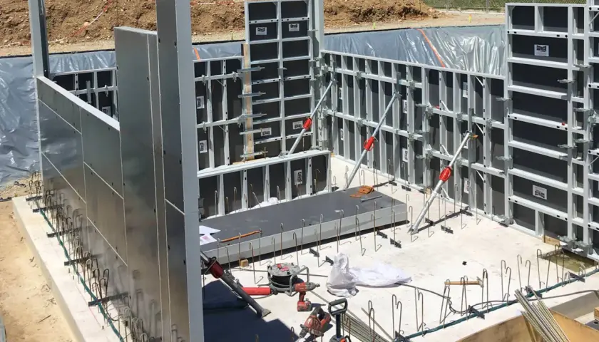 Panneaux de coffrage modulaires en aluminium et acier installés sur un chantier de construction.