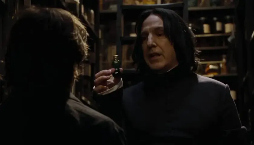 Severus Snape trzyma fiolkę z eliksirem, rozmawiając z kimś w mrocznym pomieszczeniu pełnym butelek.