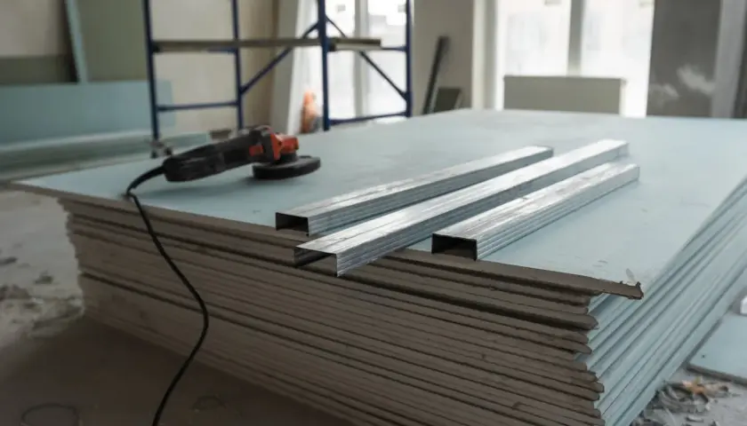 Materiali per un tutorial cartongesso: lastre, profili metallici e smerigliatrice.